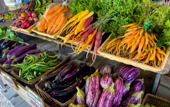 Pastanagues artesanes taronja, groc i morat en caixes de fusta apilades.