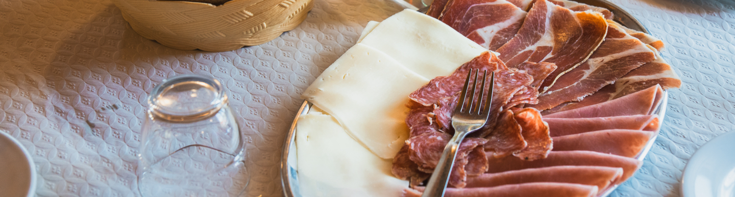 Plat d’embotits i formatge amb got invertit i pa en cistella.